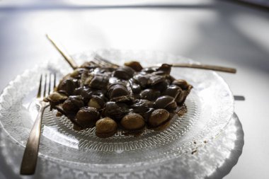 Beyaz ahşap masa üzerinde altın çatal ve bıçak ile antika bir tasarım ile şeffaf bir tabak üzerinde çikolata ile Bubble waffle