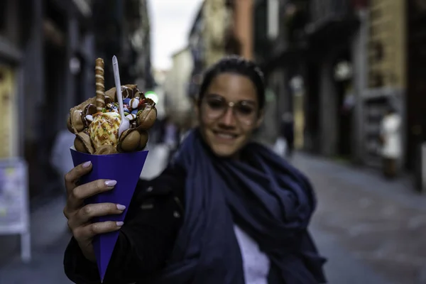 Dondurma ve candi ile bir kabarcık waffle tutan güzel kadın