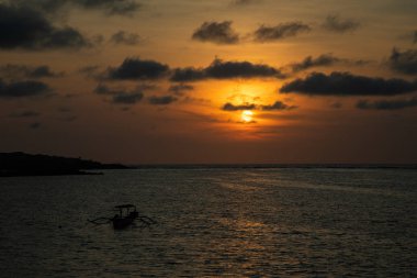 Bali tekne ile sakin okyanus üzerinde gün batımı
