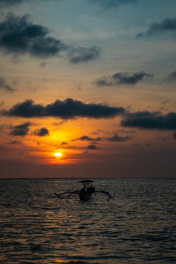 Bali tekne ile sakin okyanus üzerinde gün batımı
