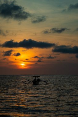 Bali tekne ile sakin okyanus üzerinde gün batımı