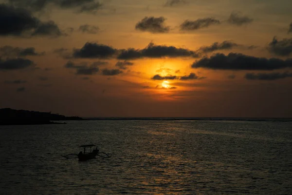 Coucher de soleil sur un océan calme avec bateau balinais — Photo