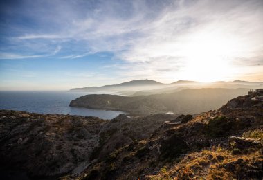 Açık gökyüzü ile deniz uçurumlar ve alçak bulutlar üzerinde gün batımı
