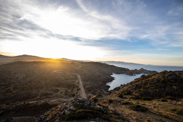 Sunset over road and sea cliffs and low clouds with clear sky