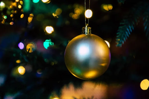 Globo de decoração dourada na árvore de natal de perto — Fotografia de Stock