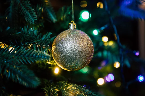 Goldene Schmuckkugel am Weihnachtsbaum aus nächster Nähe — Stockfoto