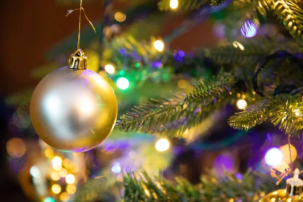 Globo de decoração dourada na árvore de natal de perto — Fotografia de Stock