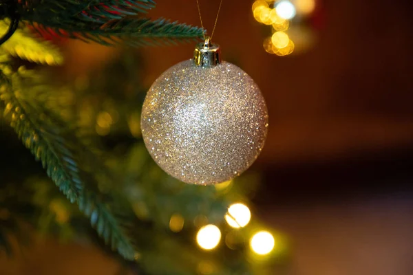 Golden decoration globe on christmas tree close up