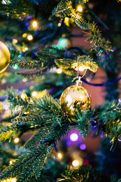 Goldene Schmuckkugel am Weihnachtsbaum aus nächster Nähe — Stockfoto