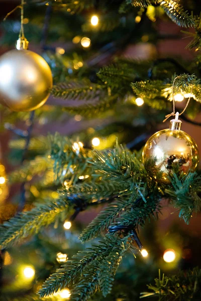 Golden decoration globe on christmas tree close up Royalty Free Stock Images