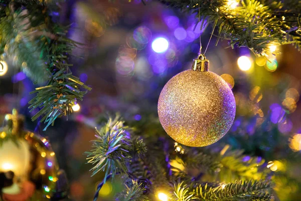 Golden decoration globe on christmas tree close up Royalty Free Stock Images