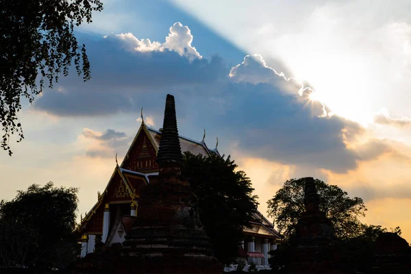 大きな雲の後ろから輝く太陽の光タイ寺院 — ストック写真