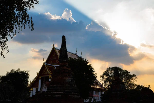 Rayos de sol brillando detrás de una gran nube en el templo tailandés — Foto de Stock