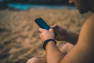Sahilde bir akıllı telefon ile satın al