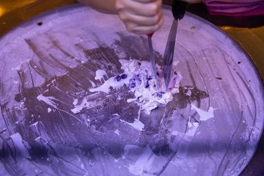 Yuvarlak soğuk tabakta dondurma yapan kadın el