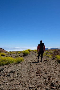 Sarı akıntı ile çevrili kuru volkanik dağ manzara adam