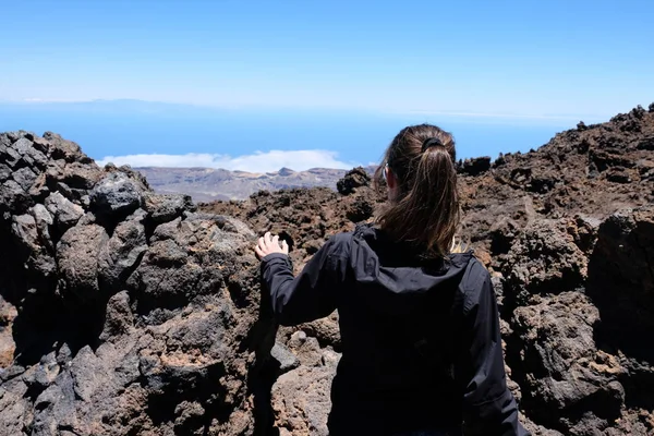 Frau besteigt den Teide-Gipfel in einer trockenen und felsigen Vulkanlandschaft — Stockfoto