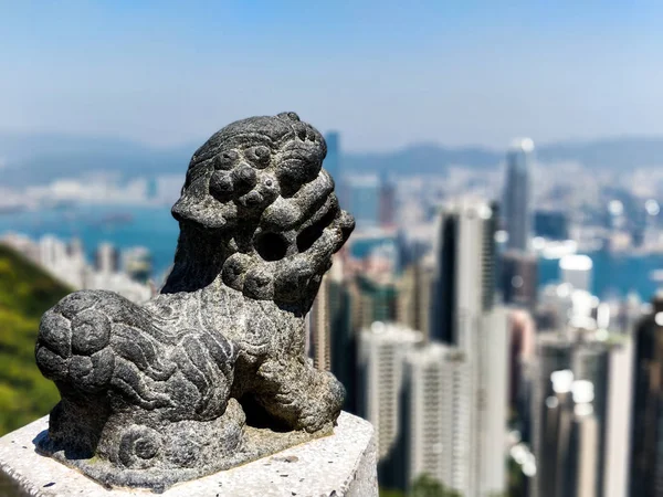 Statua asiatica con skyline di Hong Kong sfocato sullo sfondo — Foto Stock