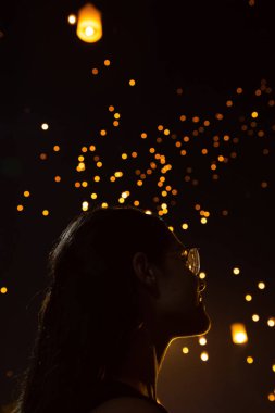 Güzel kadın silüi portre, Tayland arka planda bokeh olarak Loy Krathong kağıt fenerleri bakıyor