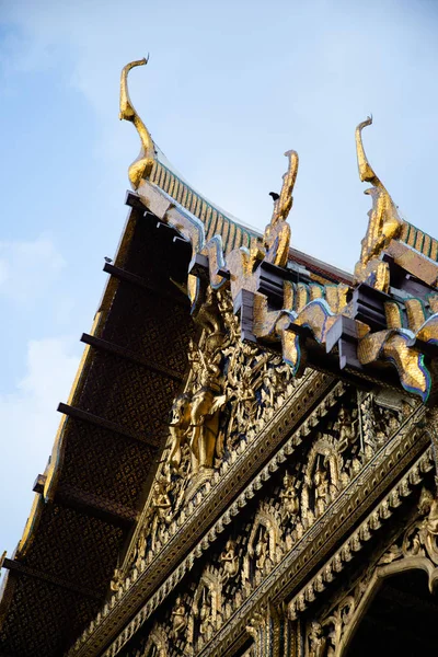 Blick von unten auf ein thailändisches Tempeldach mit blauem Himmel im Hintergrund — Stockfoto