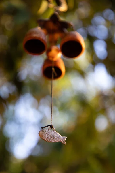 Nahaufnahme hängender Glocken mit Elefantencharme mit grünen Blättern im Hintergrund — Stockfoto