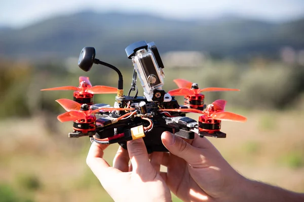 Eylem Kamera ile bir FPV yarış drone tutan eller