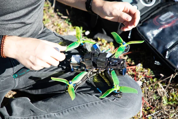 Uomo preparazione fpv drone da corsa sul giro con eliche verdi — Foto Stock