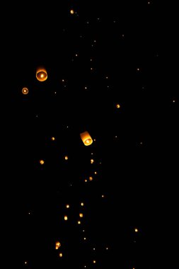 Loi Krathong and Yi Peng released paper lanterns on the sky during night clipart