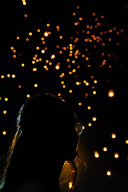 Güzel kadın silüi portre, Tayland arka planda bokeh olarak Loy Krathong kağıt fenerleri bakıyor