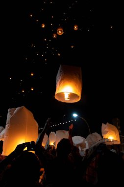 People releasing paper lanterns during Loi Krathong and Yi Peng  clipart