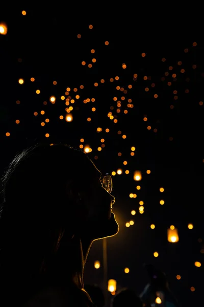 Bella donna silhouett ritratto guardando Loy Krathong lanterne di carta come bokeh sullo sfondo in Thailandia — Foto Stock