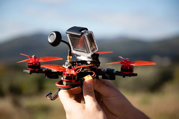 Manos sosteniendo un dron de carreras fpv con cámara de acción — Foto de Stock