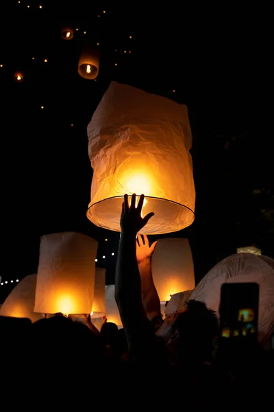 Unrecognizable man releasing paper lantern during Loi Krathong a — Stock Photo, Image