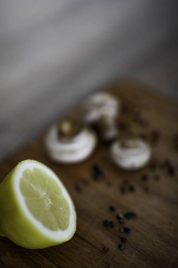 Mantar ve karabiber ile ahşap bir kesme tahtasında yarım limon