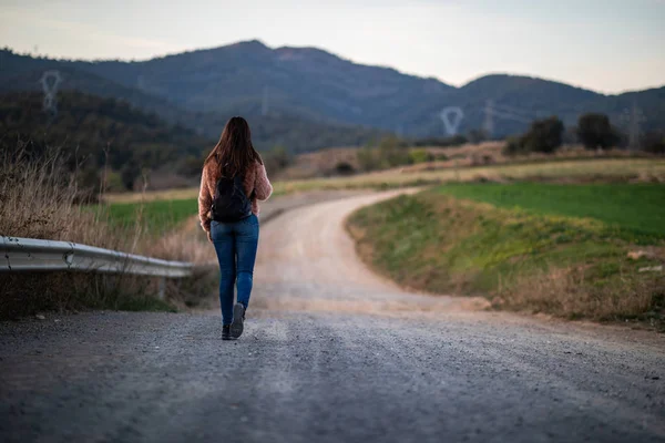 Arka planda bulanık yol ve dağlar ile bir köprü üzerinde güzel kadın yürüyüş