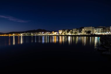 Şehir ışıkları ile deniz üzerinde gece bir sahil şeridi uzun pozlama