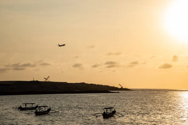 Coucher de soleil sur la plage avec une silhouette d'avion décollant — Photo