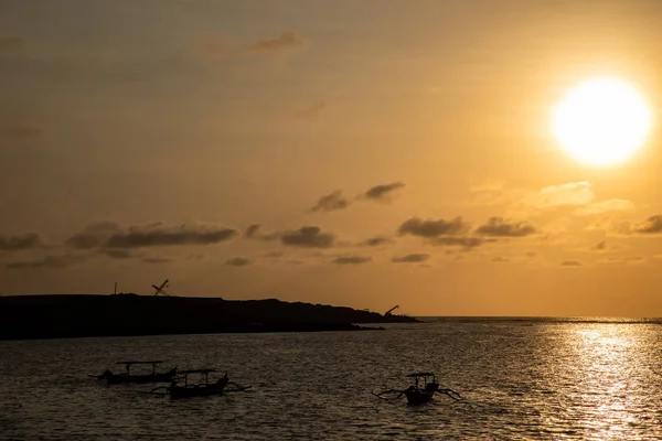 Coucher de soleil sur la plage avec des bateaux silhouettes à Bali — Photo