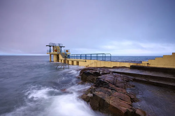 Blackrock Dalış Kulesi farklı seviyelerde çeşitli dalış platformları ile bir iskele ve arka planda Galway Bay ile Salthill gezinti sonunda yer almaktadır