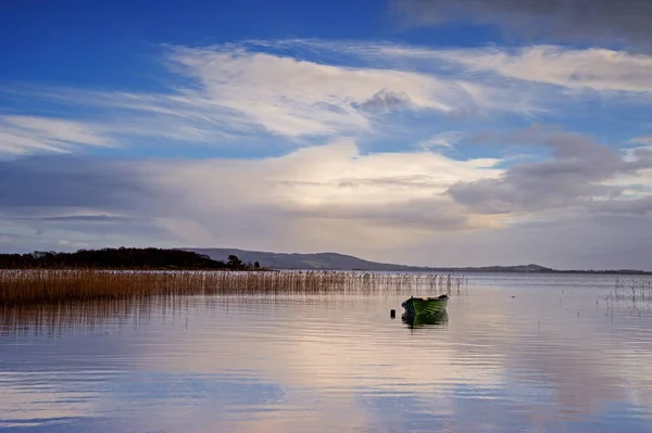曇り空の背景に湖で単独のボート — ストック写真