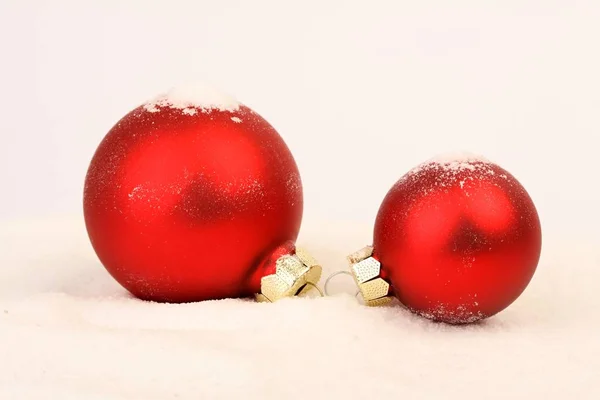 雪地上的两个红色哑光圣诞球 雪地背景上的两个雪哑红圣诞球 白色背景玻璃红球 — 图库照片