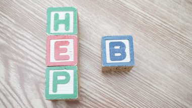 wooden cubes with word hep b on brown background  clipart