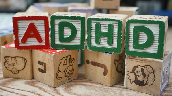 Kahverengi arka planda kelime adhd ile tahtadan küpler 