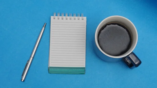 一杯茶 记事本和笔在蓝色背景 顶视图 — 图库照片