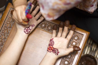 Usta kadın eline kına uyguluyor