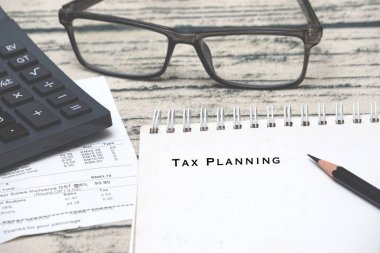 Hesap makinesi, alış irsaliyesi, cam ve Not defteri ile yazılı vergi planlaması. Taxing kavramı