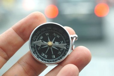 Doğa arka plan üzerinde manyetik pusula tutan el