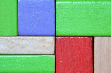 Kırmızı, kahverengi, yeşil ve mor ahşap oyuncak blokları oluşturulan kare şekil renkli arka plan. Tasarım, harfler, semboller veya logonuz için hazır