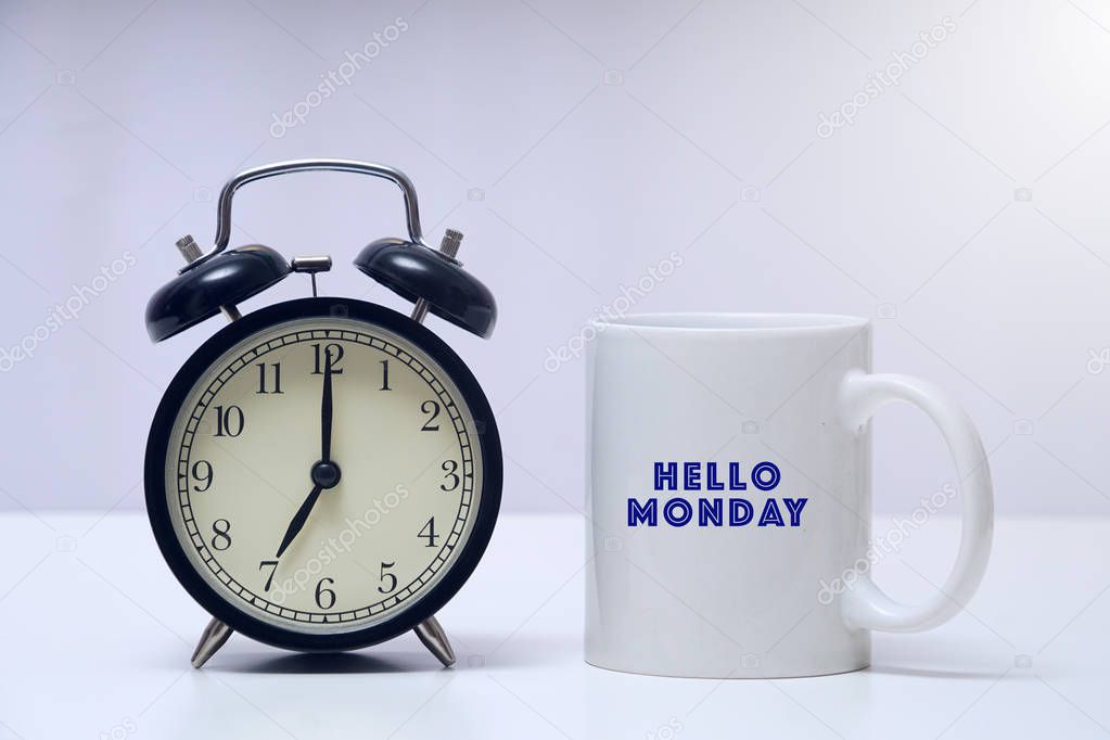 Vintage alarm clock with a mug written HAPPY MONDAY