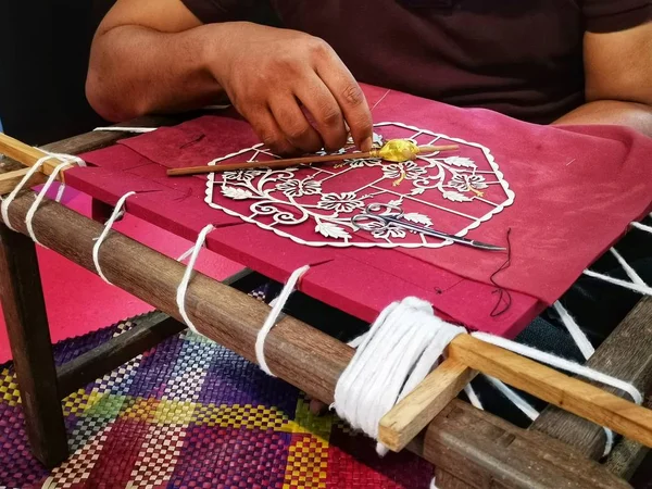 Kuala Lumpur, Malezya-Nisan 2019: Malezya yerel kullanışlı zanaat sanat çalışmaları sanat sergisi sırasında gerçekleştirir. Özel bir kumaşta dokuma yapan bir adamın eli